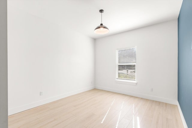 unfurnished room with light wood-style flooring and baseboards