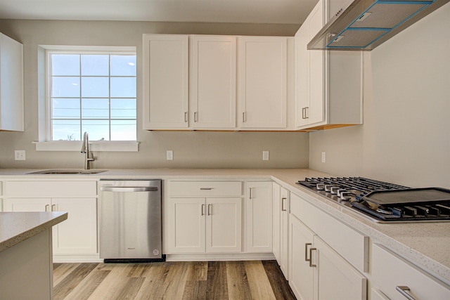 kitchen featuring appliances with stainless steel finishes, sink, white cabinets, and light hardwood / wood-style floors