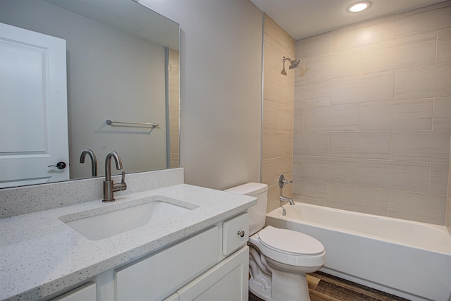 full bathroom featuring vanity, toilet, tiled shower / bath combo, and wood-type flooring