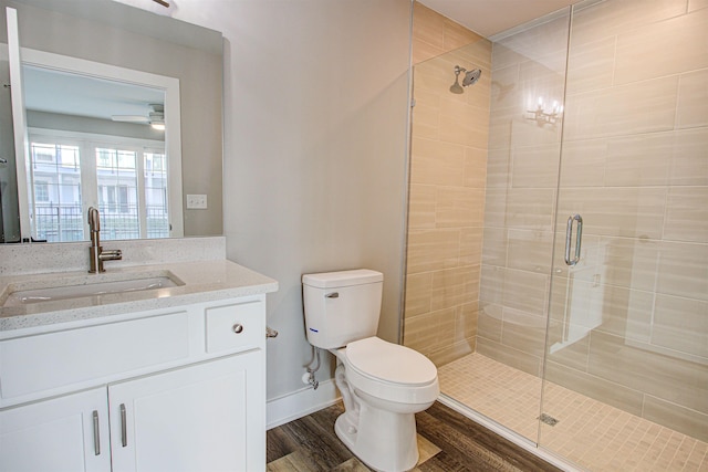 bathroom with hardwood / wood-style flooring, vanity, an enclosed shower, and toilet