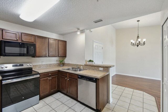 unfurnished living room featuring ceiling fan with notable chandelier, washer / dryer, light hardwood / wood-style floors, and vaulted ceiling