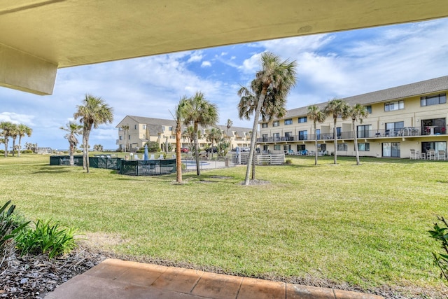 view of home's community featuring a residential view, fence, and a yard