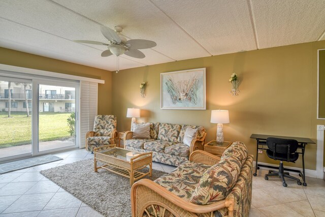 living room with tile patterned flooring, ceiling fan, and baseboards