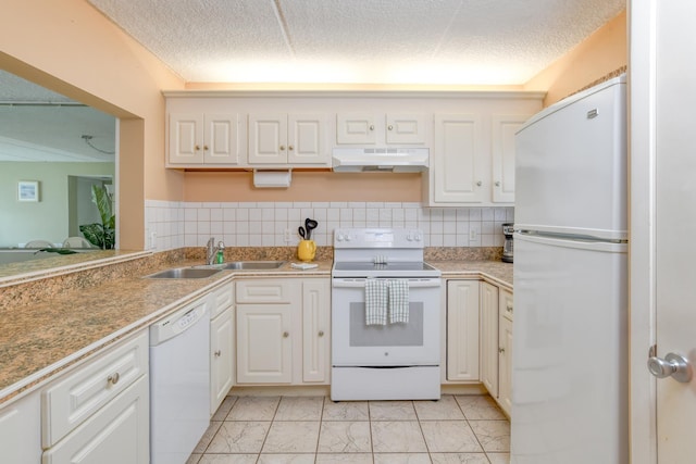 kitchen with a textured ceiling, under cabinet range hood, white appliances, a sink, and marble finish floor