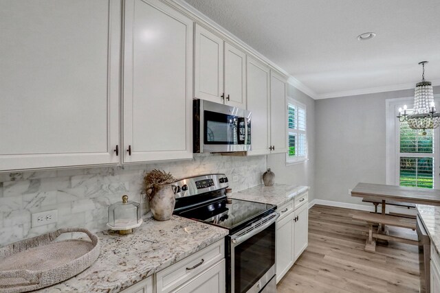 119 Duck Pond Dr, Saint Augustine, FL 32086 - kitchen with light wood-type flooring, a notable chandelier, stainless steel appliances, crown molding, and decorative backsplash