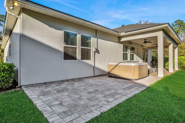119 Duck Pond Dr, Saint Augustine, FL 32086 - back of house with a hot tub, ceiling fan, stucco siding, a yard, and a patio