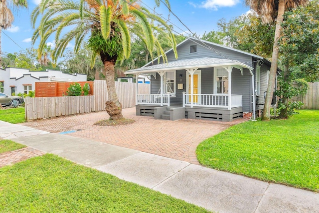 bungalow-style house featuring covered porch and a front lawn