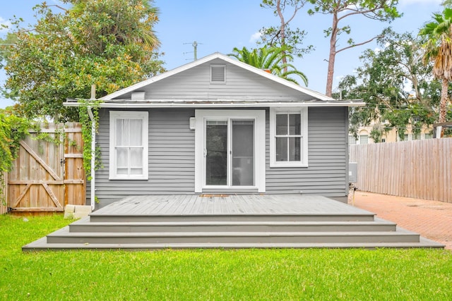 rear view of house with a yard and a deck