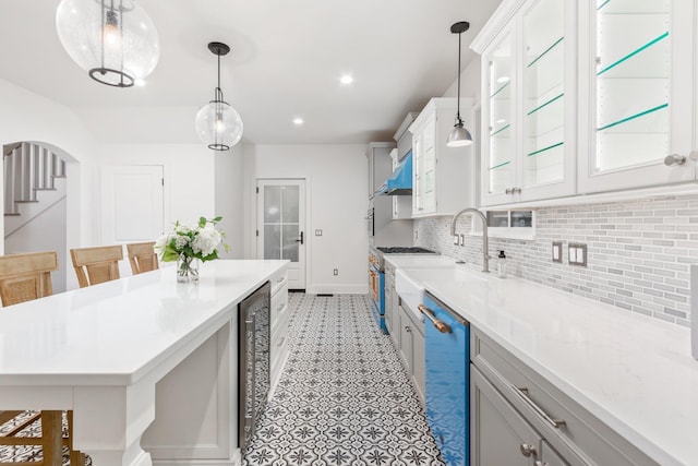 kitchen featuring dishwasher, a breakfast bar, white cabinets, and backsplash