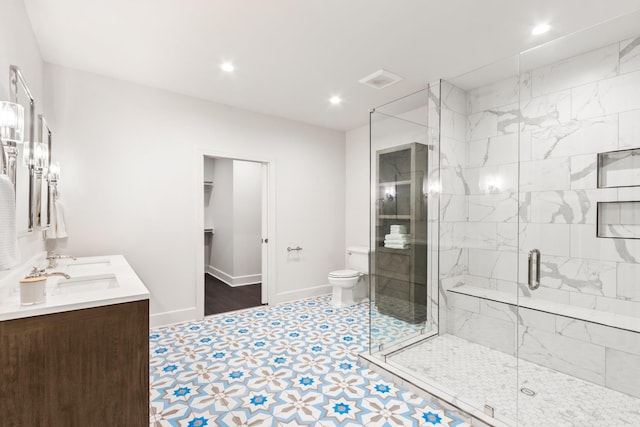 bathroom with a shower with door, vanity, and toilet