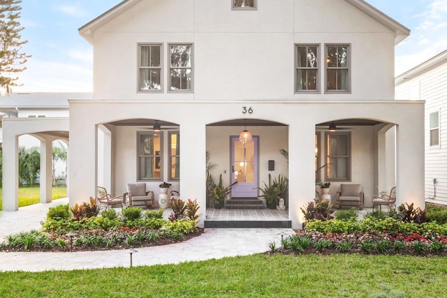 back of house featuring a porch and stucco siding