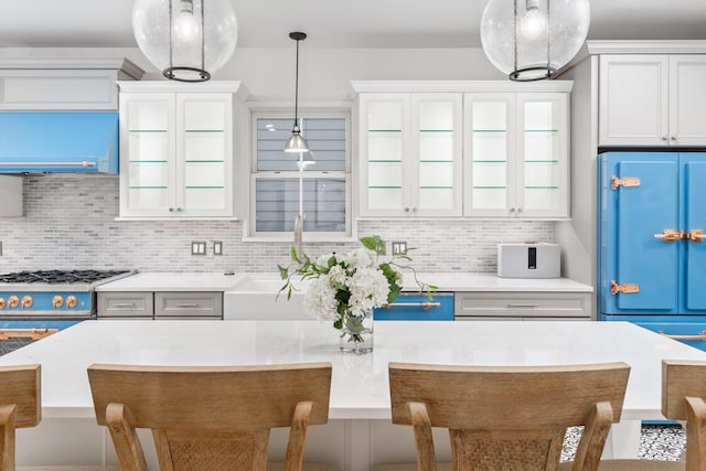 kitchen with sink, a center island, tasteful backsplash, a kitchen bar, and decorative light fixtures