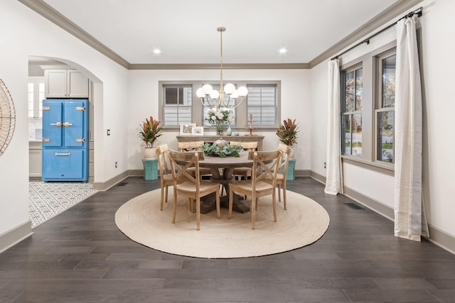 dining area featuring ornamental molding, dark hardwood / wood-style flooring, and a chandelier