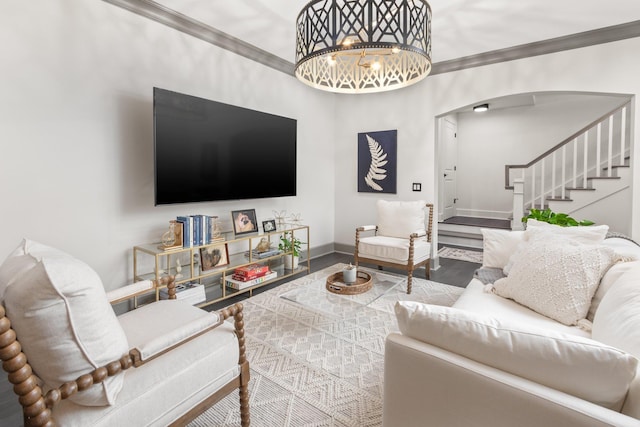 living room with hardwood / wood-style flooring, ornamental molding, and a chandelier