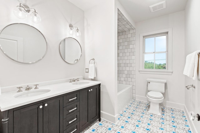 full bathroom featuring vanity, tiled shower / bath combo, tile patterned floors, and toilet