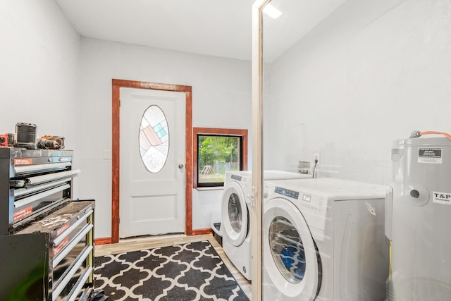 clothes washing area with electric water heater, separate washer and dryer, and light hardwood / wood-style flooring