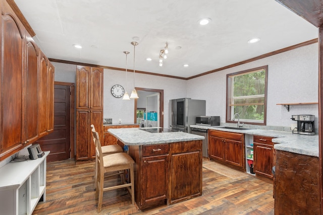 kitchen featuring stainless steel appliances, sink, a center island, dark hardwood / wood-style floors, and hanging light fixtures