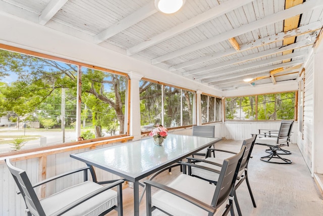 sunroom / solarium featuring beamed ceiling