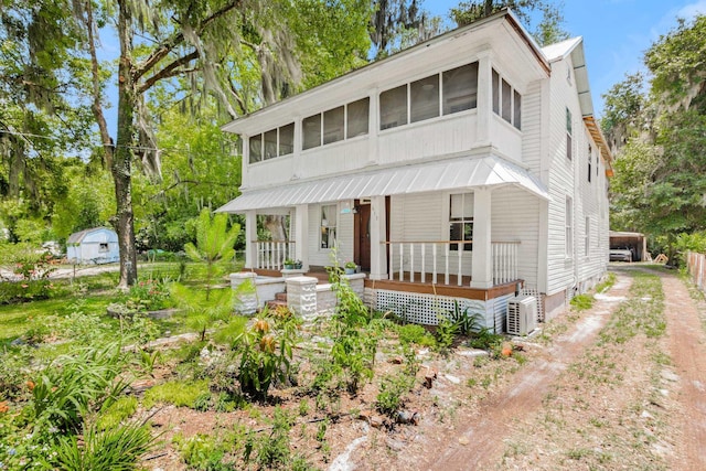 view of front facade featuring covered porch, a carport, and a sunroom