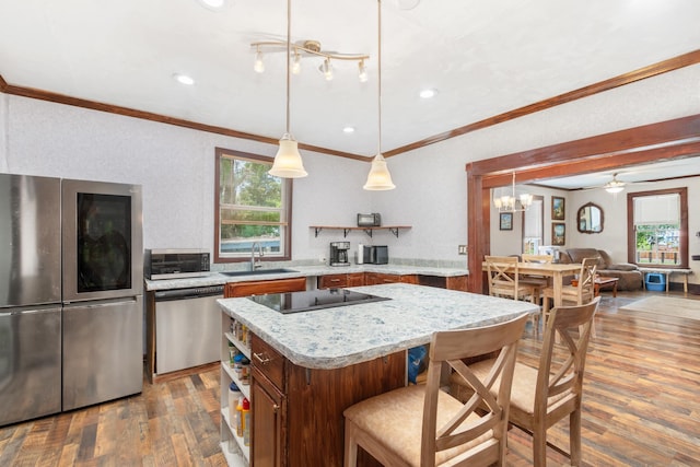 kitchen with a center island, crown molding, sink, hardwood / wood-style flooring, and stainless steel appliances