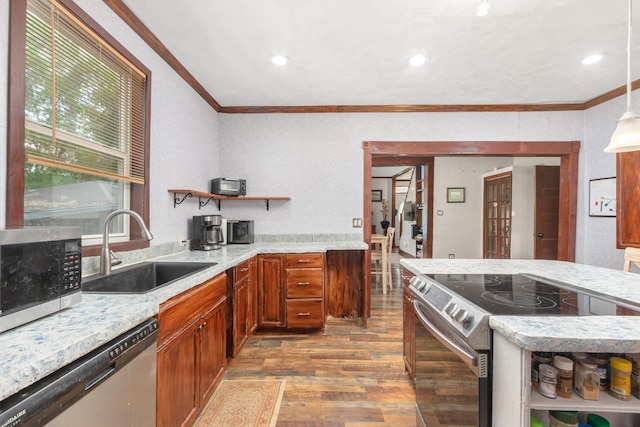 kitchen with sink, stainless steel appliances, crown molding, hardwood / wood-style floors, and pendant lighting