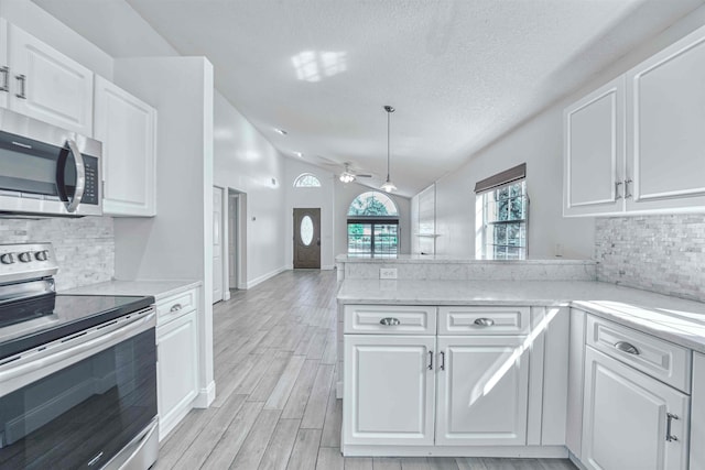 kitchen with stainless steel appliances, a ceiling fan, and white cabinetry