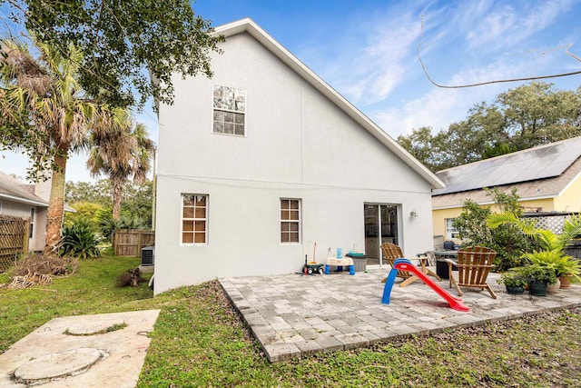 rear view of house with a patio, a yard, fence, and stucco siding