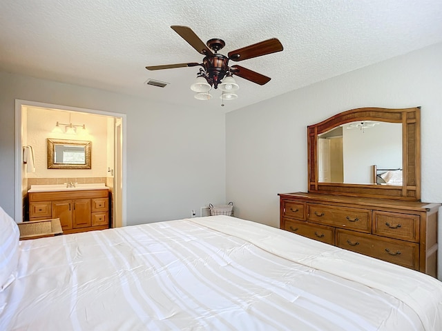 bedroom with sink, ensuite bath, a textured ceiling, and ceiling fan