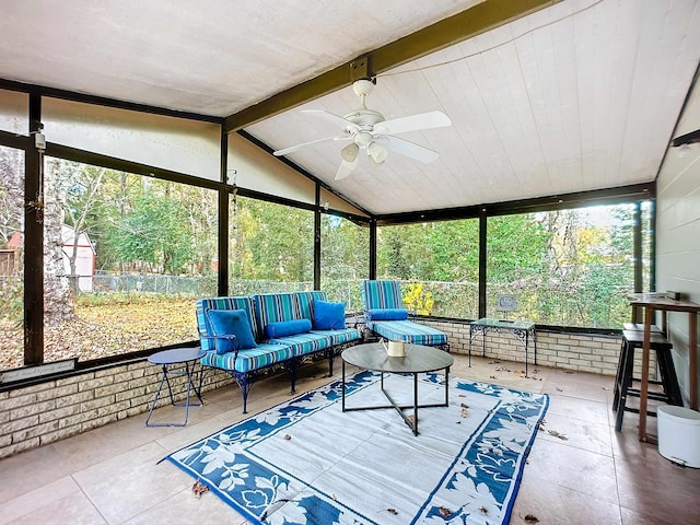 sunroom with a healthy amount of sunlight, lofted ceiling with beams, and ceiling fan