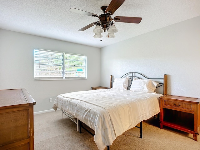 carpeted bedroom featuring a textured ceiling and ceiling fan