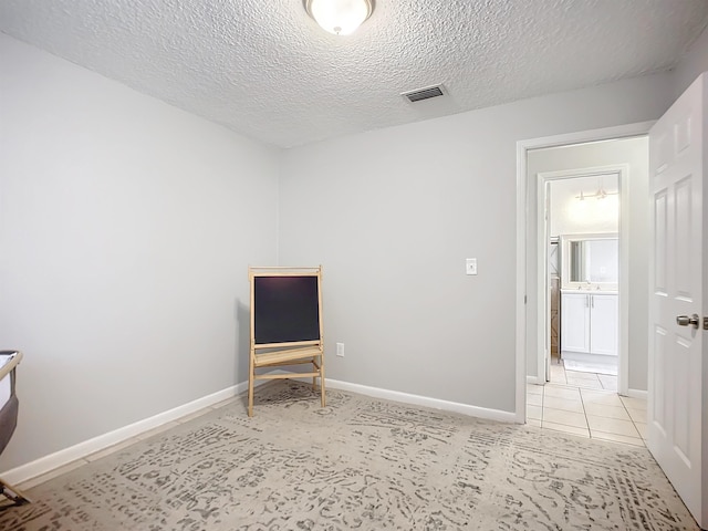 living area featuring light tile patterned floors and a textured ceiling