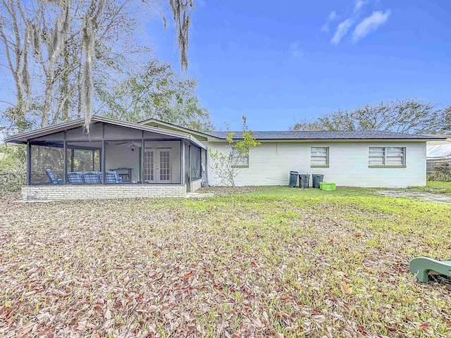 back of house featuring a yard and a sunroom