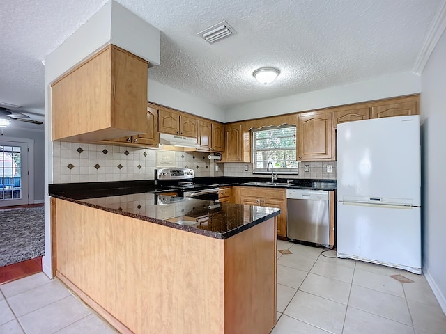 kitchen featuring sink, light tile patterned floors, ceiling fan, kitchen peninsula, and stainless steel appliances