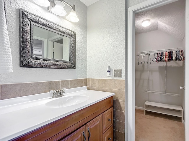 bathroom with vanity, tile walls, and a textured ceiling