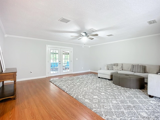 living room featuring french doors, crown molding, a textured ceiling, ceiling fan, and hardwood / wood-style floors