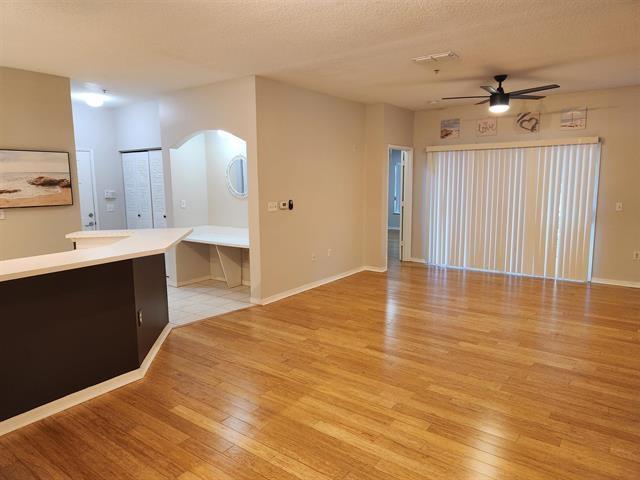 interior space featuring ceiling fan, light hardwood / wood-style flooring, and a textured ceiling