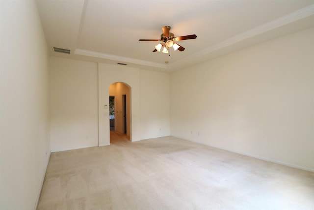 5850 Cypress Estates Dr, Elkton, FL 32033 - spare room with arched walkways, light colored carpet, ceiling fan, ornamental molding, and a tray ceiling