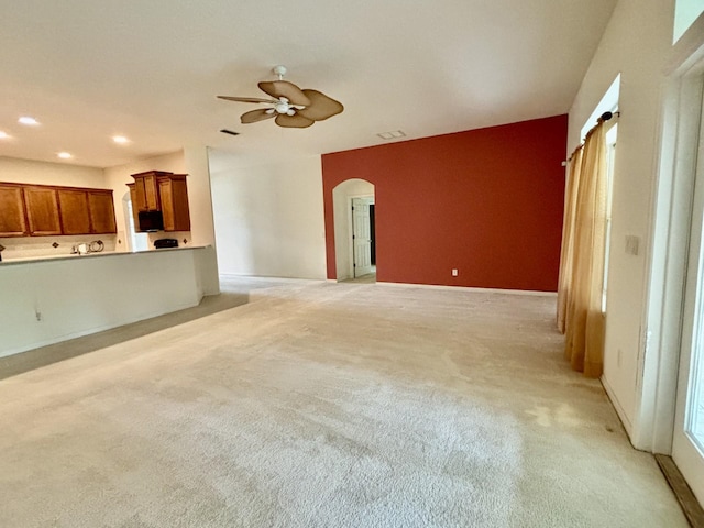 5850 Cypress Estates Dr, Elkton, FL 32033 - unfurnished living room with arched walkways, a ceiling fan, light colored carpet, and recessed lighting