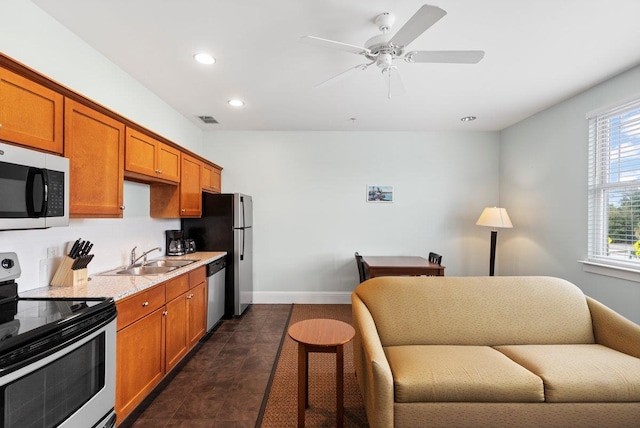 kitchen with stainless steel appliances, brown cabinetry, a sink, and visible vents