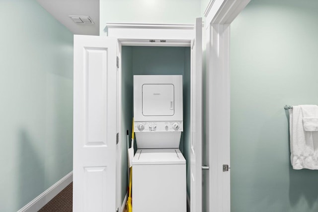 washroom with laundry area, carpet floors, visible vents, baseboards, and stacked washer and clothes dryer