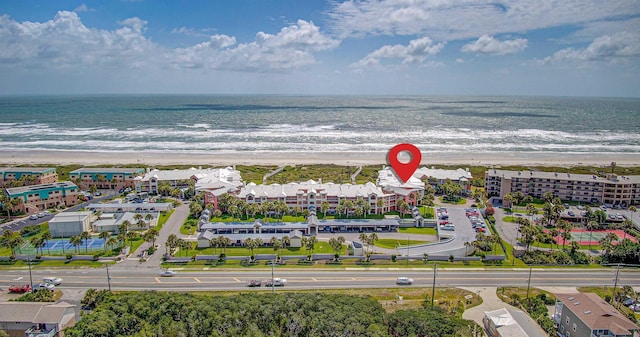 drone / aerial view featuring a water view and a view of the beach