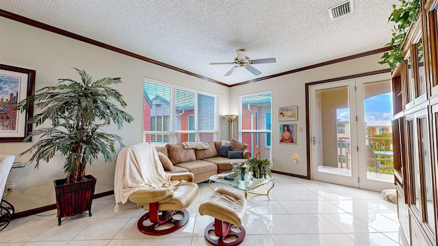 tiled living room featuring ceiling fan, ornamental molding, and a textured ceiling