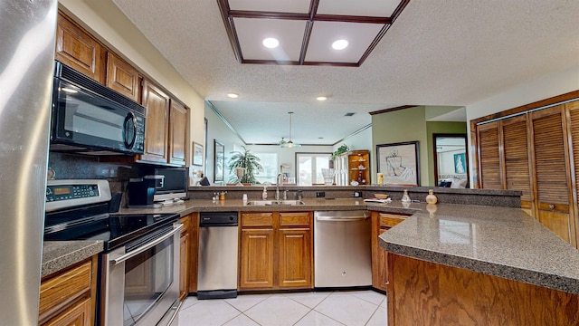 kitchen with sink, ceiling fan, a textured ceiling, appliances with stainless steel finishes, and kitchen peninsula