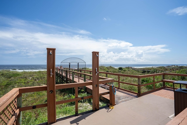 wooden terrace with a view of the beach and a water view