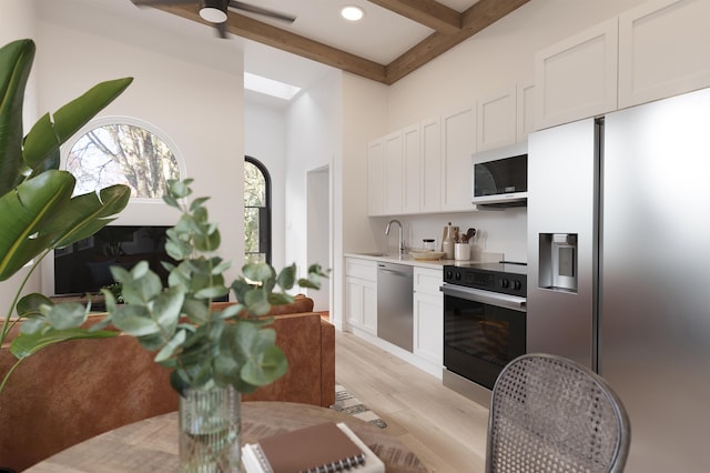 53 Hernandez Ave, Palm Coast, FL 32137 - kitchen featuring light wood-type flooring, ceiling fan, beamed ceiling, light countertops, and appliances with stainless steel finishes