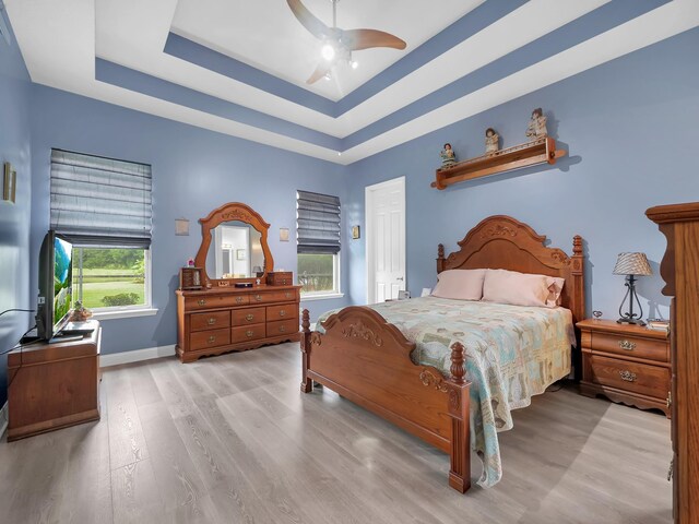 1201 Ellington Ct, Saint Augustine, FL 32084 - bedroom with light wood-type flooring, a tray ceiling, and a ceiling fan