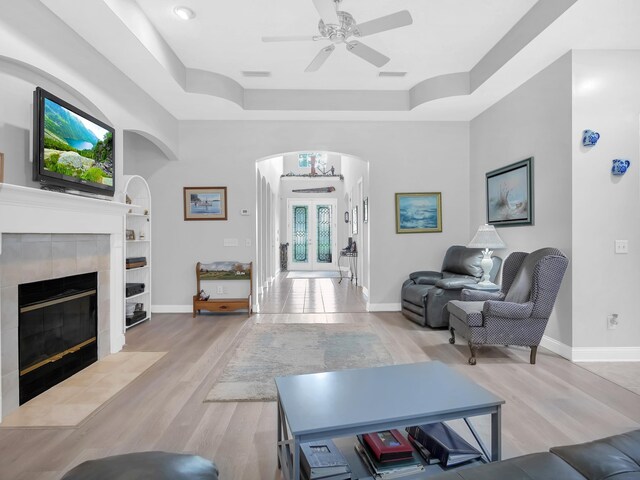 1201 Ellington Ct, Saint Augustine, FL 32084 - living area featuring arched walkways, a tray ceiling, a ceiling fan, light wood-type flooring, and built in shelves