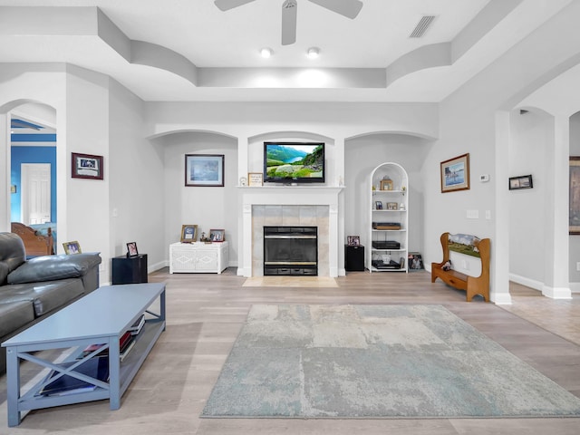 1201 Ellington Ct, Saint Augustine, FL 32084 - living area featuring ceiling fan, a fireplace, arched walkways, and light wood-style floors
