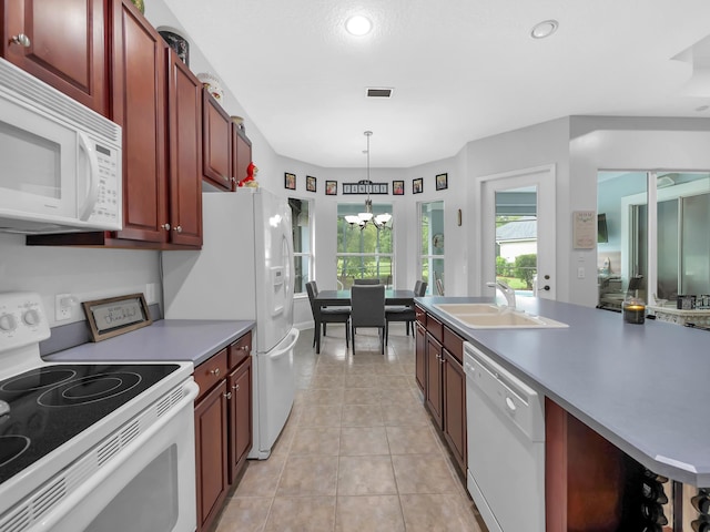 1201 Ellington Ct, Saint Augustine, FL 32084 - kitchen with white appliances, a chandelier, light tile patterned floors, decorative light fixtures, and dark brown cabinets