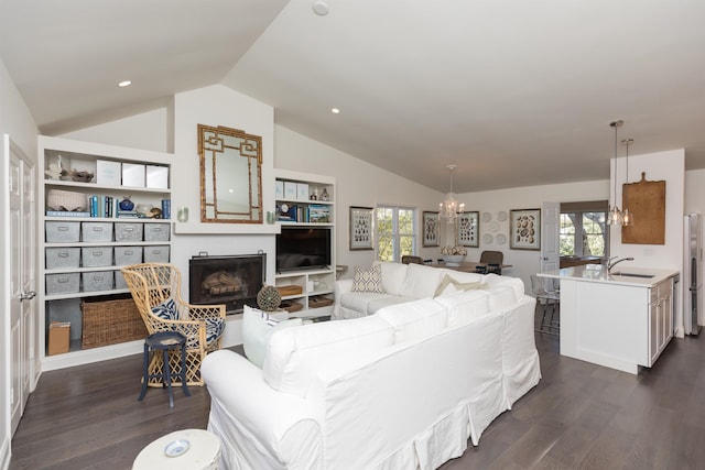 6698 Nassau St, Saint Augustine, FL 32080 - living area featuring vaulted ceiling, a chandelier, dark wood-type flooring, a fireplace, and plenty of natural light
